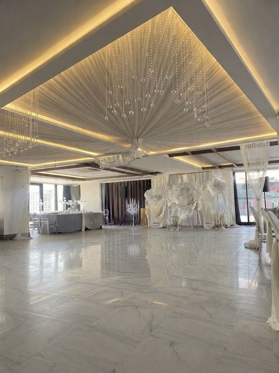 Tavan drape kumaş süslemesi ve sarkan kristallerle kapalı davet salonu.