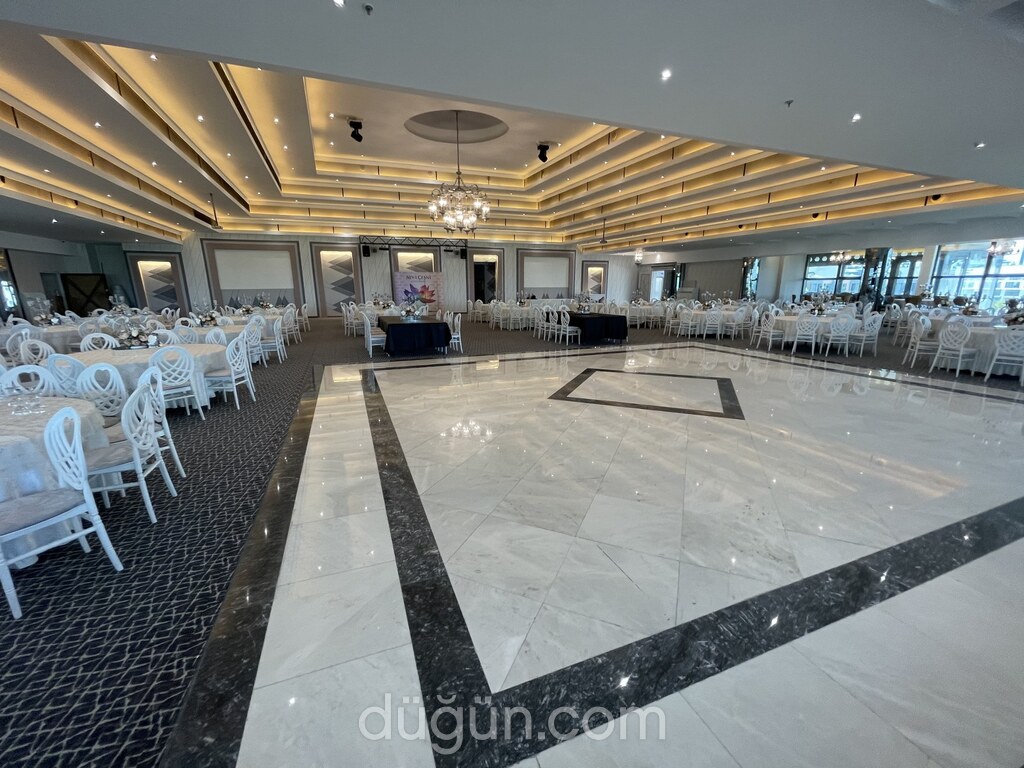 Geniş dans pisti ve etrafında sıralanmış masalarıyla balo salonu.