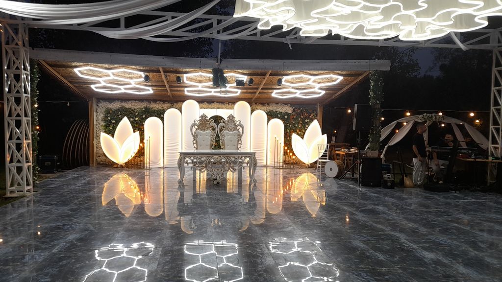 Geometrik tavan ışıkları altında gelin damat masası ve dans pisti.