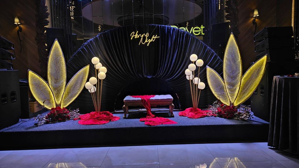 Siyah fon, ışıklı yaprak dekorları ve Henna Night yazılı sahne düzeni.