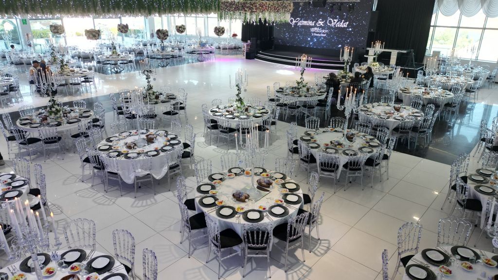 Yüksek açıdan kristal şamdanlı masalar ve geniş dans pistiyle davet salonu.