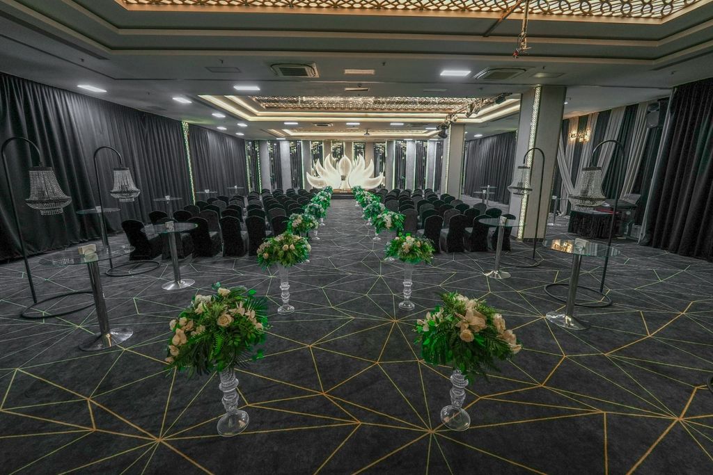 Geometrik desenli halı üzerinde çiçeklerle belirlenmiş gelin yolu ve nikah seremonisi düzeni.