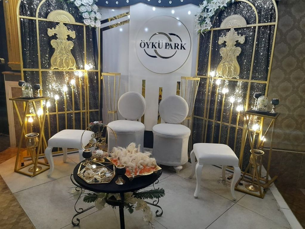 Işıklı arka fon, beyaz koltuklar ve sehpa ile hazırlanmış söz ve nişan alanı.